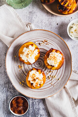 Grilled peaches with cottage cheese, nuts and honey on a plate top and vertical view