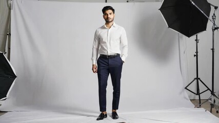 Indian man modeling formal business attire during a photoshoot, presenting a confident and elegant appearance against a neutral white background with studio lighting - Powered by Adobe