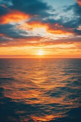 Fototapeta premium Fiery sunset paints ocean waves with golden light horizon