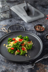 Delicious broccolini salad with toasted breadcrumbs and chili pepper flakes on black plate