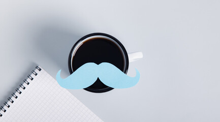 Mustache on a coffee mug, notebook, mustache health day concept top view web banner