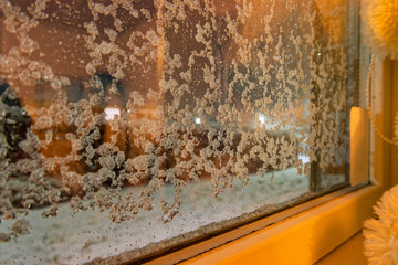 Snow flecks on window, plush bear peeks from the sill