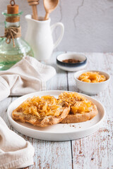 Appetizing croutons with stewed apple strips on a plate on the table vertical view