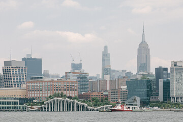 Urban skyline of New York City with modern buildings and iconic features under a cloudy sky