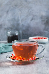 Detox green pomegranate tea in a cup on the table vertical view