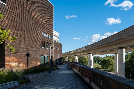 Brick and concrete layers in Stockholm urban environment, elevated walkway connecting architectural structures, design composition highlighting material contrast and visual rhythm