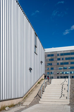 Metallic fa&ccedil;ade and stair access in Stockholm urban complex under blue sky, architectural rhythm and vertical design offering minimalist modern composition for visual creativity