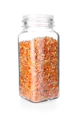 Dried carrots in glass jar isolated on white. Aromatic spice