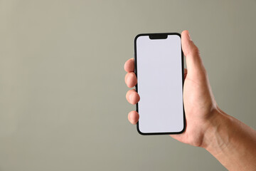 Man with modern smartphone on beige grey background, closeup. Mockup for design