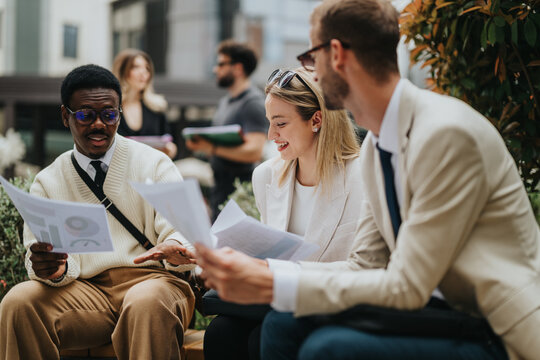 Group of professionals reviewing papers together in an open-air city environment, sharing insights and planning effectively. The photo exudes collaboration, teamwork, and creativity. - Powered by Adobe