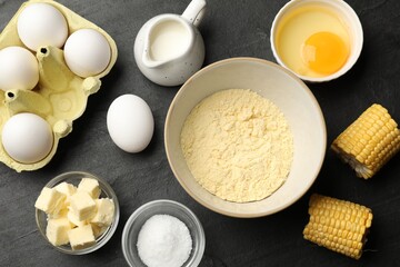 Cornbread preparation. Different ingredients on black textured table, flat lay