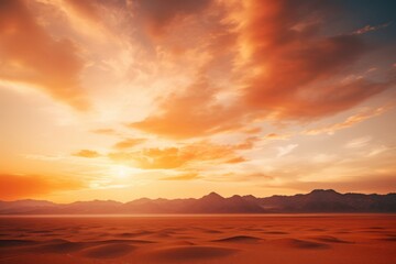 Fiery sunset paints desert dunes and distant mountains sand