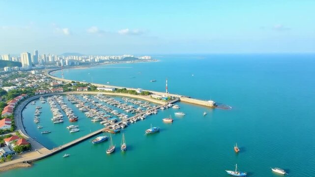 Aerial view of the harbor on Phu Quoc island, Vietnam, showing hundreds of fishing boats, coastal homes, and the oceanfront city skyline under clear blue skies.