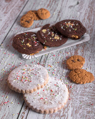 Assorted cookies with chocolate and sugar, decorated with sprinkles and served with a glass of milk, sweet dessert for holidays and celebrations