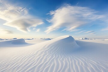 White sand dunes under a bright blue sky with clouds snow desert