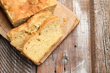 Freshly baked cut cornbread on wooden table, top view. Space for text