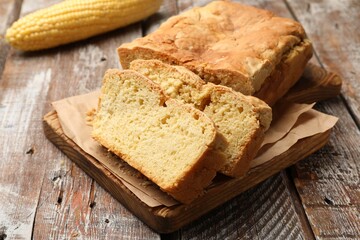 Freshly baked cut cornbread on wooden table, closeup