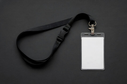 Blank white identification badge on black lanyard against dark background blank badge white badge