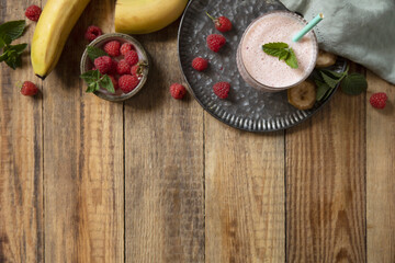 Refreshing banana raspberry smoothie with fresh mint for healthy living and summer enjoyment. Top view flat lay background.