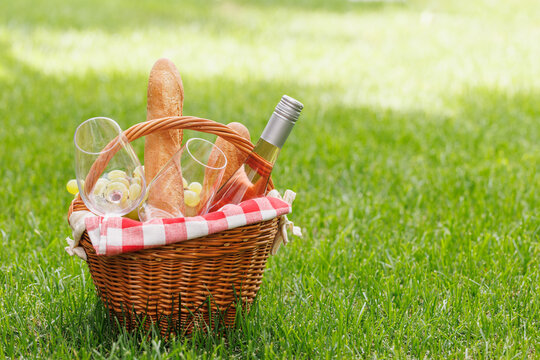 Picnic basket with wine, grapes, and baguette