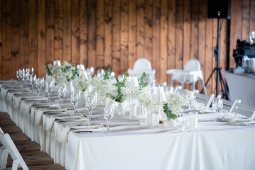 beautiful table setting with flowers and cutlery on wooden table at wedding or dinner. stylish tablewear decorations	