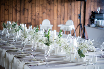 beautiful table setting with flowers and cutlery on wooden table at wedding or dinner. stylish tablewear decorations	