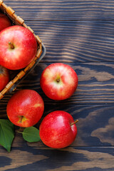 Basket of ripe red apples on a wooden table