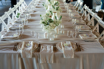 beautiful table setting with flowers and cutlery on wooden table at wedding or dinner. stylish tablewear decorations	