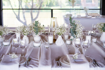 beautiful table setting with flowers and cutlery on wooden table at wedding or dinner. stylish tablewear decorations	