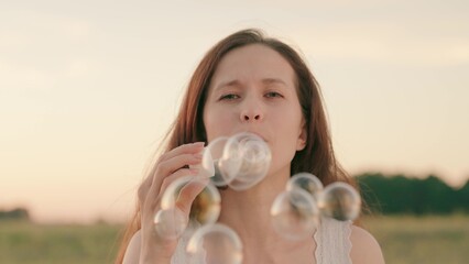 woman blowing soap bubbles park. festive mood. women outdoor recreation. happy woman vacation travel. beautiful transparent balloons outdoors. fun relaxing fun game play. holiday entertainment dream