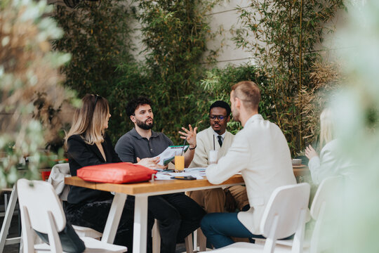 A group of diverse business professionals conversing during an outdoor team meeting.