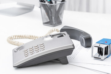 Office scene with telephone and desk accessories during a busy workday in a professional environment