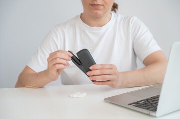 A woman takes a tobacco heating system out of a charger. Electronic cigarette.