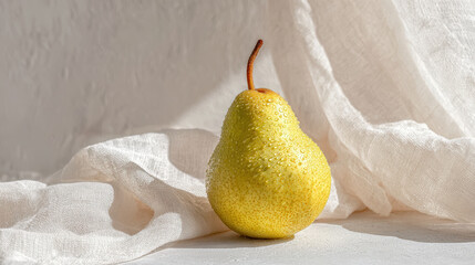 juicy pear rests elegantly against backdrop of linen fabric soaked in warm summer sunlight