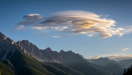 Majestic mountain range under a lenticular cloud formation at sunset, with golden light illuminating the peaks and creating a dramatic, scenic vista