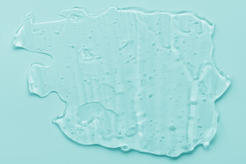 Transparent liquid gel texture beauty serum on mint background. Mint abstract art background.