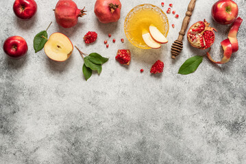 Apples, pomegranate and honey on a light rustic background. Traditional Jewish food. New Year - Rosh Hashanah. Top view, flat lay, banner, copy space
