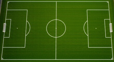 Fototapeta premium Full frame view of sports stadium with artificial green grass. Soccer field from above for competition.