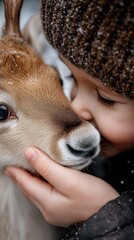 Young caucasian child affectionately embracing a calf on a snowy day