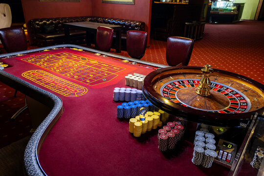 Roulette table in casino. Casino American Roulette gambling table with a wheel and playing chips on the layout.