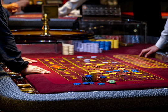 Close up of a Roulette Table. People play poker in the casino. Croupier behind gambling table in a casino