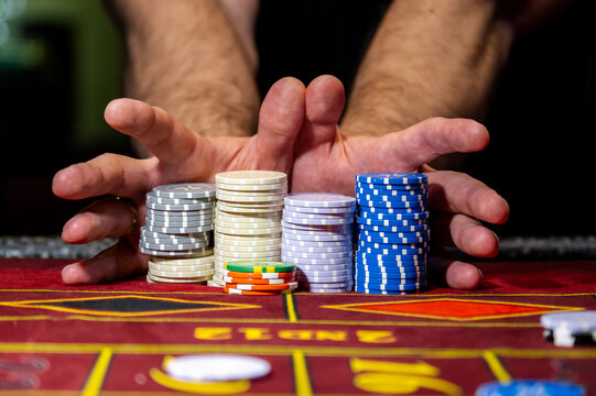 A player playing in a casino raises bets with chips. Gaming business. A player playing in a casino raises the bet with chips. Gaming business.