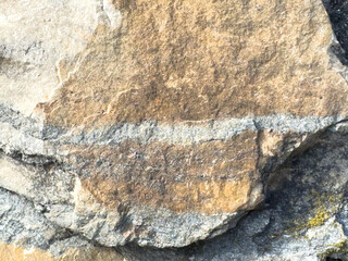 Close-up of rough textured rock face with natural layers and color variations