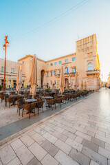 Fototapeta premium Zadar, Croatia. Old town street of Zadar with the Church of St. Donatus and the bell tower of the Cathedral of St. Anastasia at sunset.