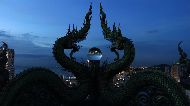 Video background of Chonburi city viewpoint. At the Samnaksong Khao Phra Khru viewpoint in the Sri Racha Thailand,a beautiful Naga statue and a white Buddha statue stand tall among the mountains.