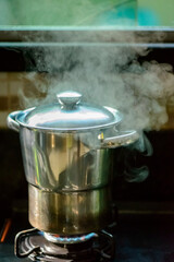 Traditional Cuscuz Steamer Pot with Steam on Gas Stove