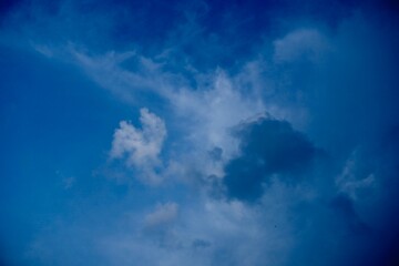 Delicate wispy clouds floating in blue atmosphere