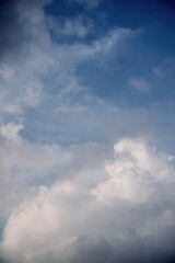 Fluffy cumulus clouds rising high in blue sky