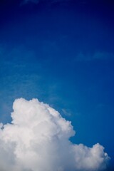 White cloud at the bottom left with a deep blue sky