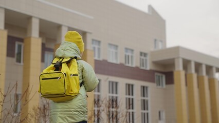 a small child with a backpack goes to school, a kid with a school bag rushes to class, happy girl, first-grade student, a schoolgirl of an educational institution, children's time to learn new things